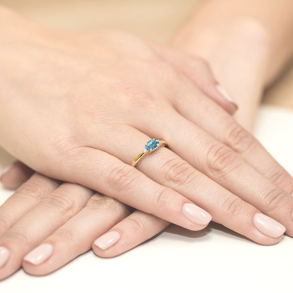 Pierścionek z topazem Swiss Blue 0,50 ct i brylantami, żółte złoto 585, zdjęcie na dłoni