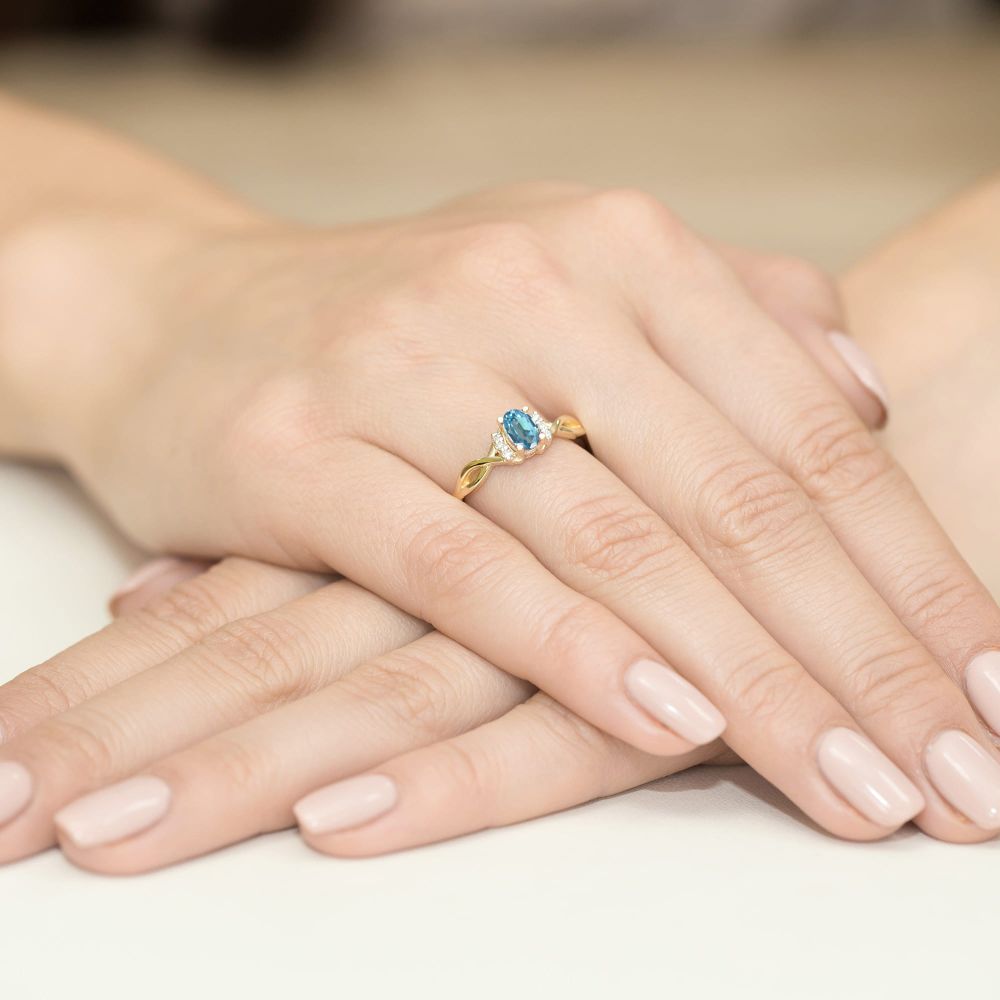 Pierścionek z topazem Swiss Blue 0,50 ct i brylantami, żółte złoto 585, zdjęcie na dłoni