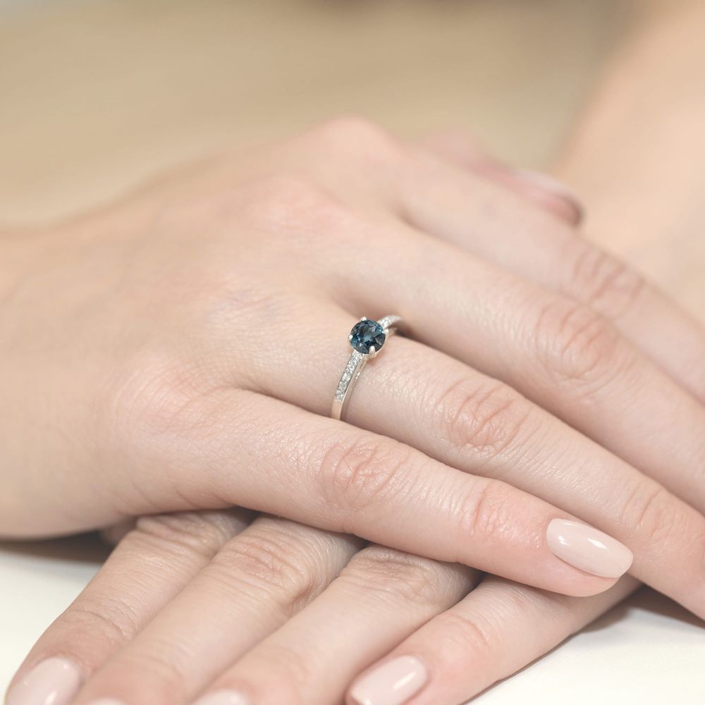 Pierścionek z topazem London Blue 0,50 ct i brylantami, białe złoto 585, zdjęcie na dłoni
