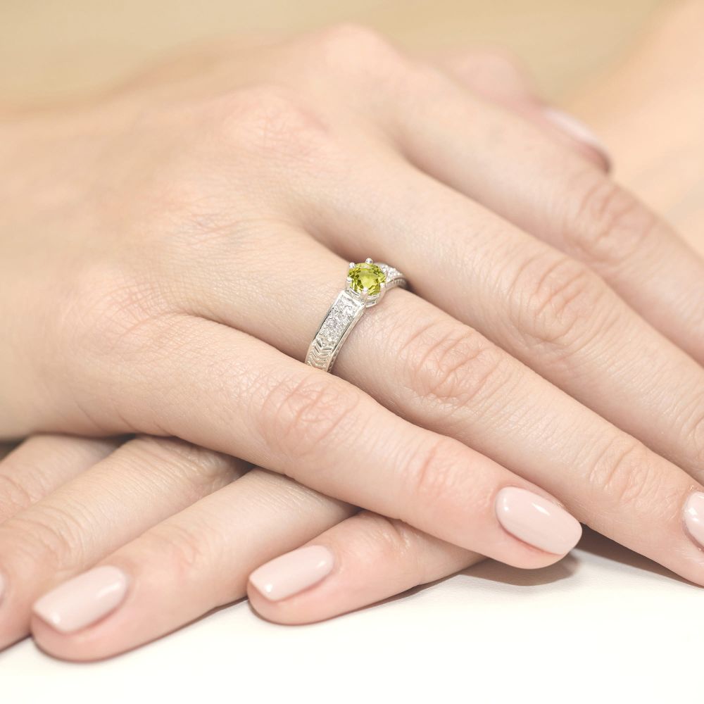 Pierścionek z oliwinem 0,60 ct i brylantami, białe złoto 585, zdjęcie na dłoni