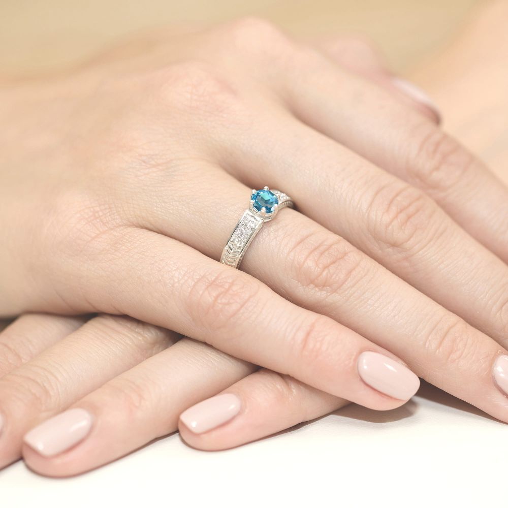 Pierścionek z topazem Swiss Blue 0,50 ct i brylantami, białe złoto 585, zdjęcie na dłoni