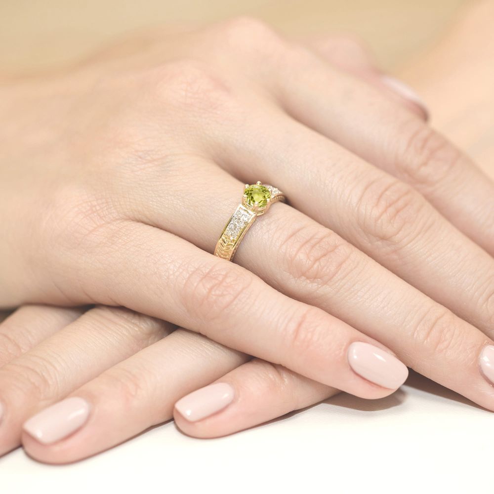 Pierścionek z oliwinem 0,60 ct i brylantami, żółte złoto 585, zdjęcie na dłoni