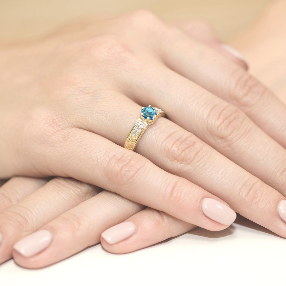 Pierścionek z topazem Swiss Blue 0,50 ct i brylantami, żółte złoto 585, zdjęcie na dłoni