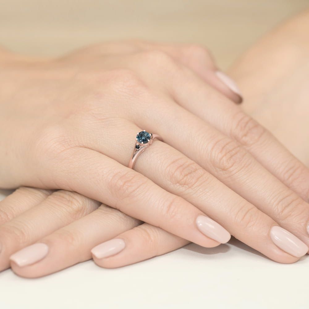 Pierścionek z topazem London Blue 0,50 ct i czarnymi brylantami, różowe złoto 585, zdjęcie na dłoni