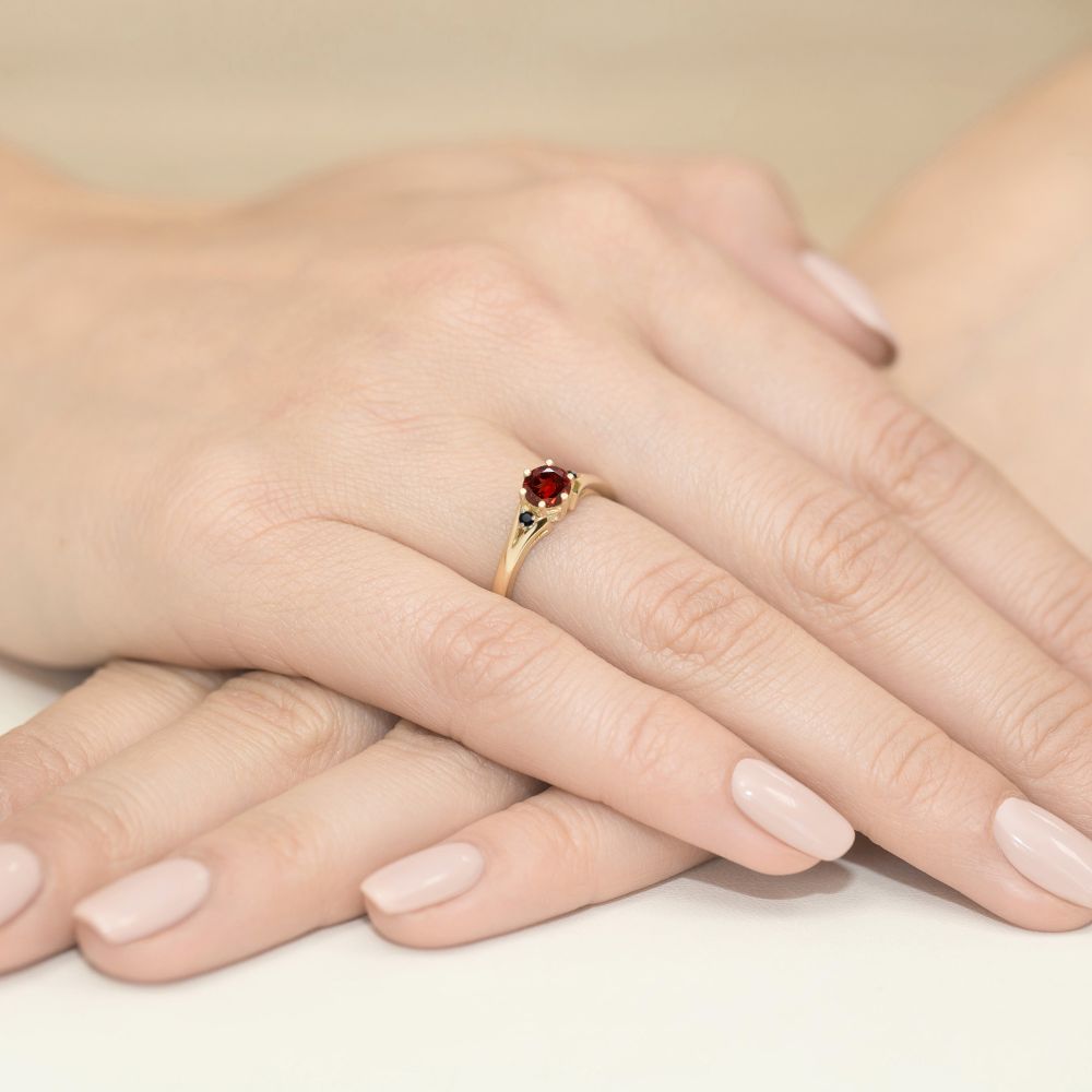 Pierścionek z granatem 0,60 ct i czarnymi brylantami, żółte złoto 585, zdjęcie na dłoni
