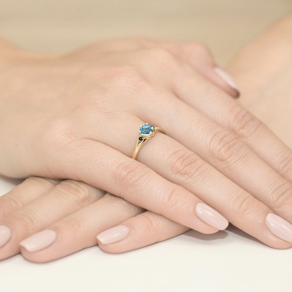 Pierścionek z topazem Swiss Blue 0,50 ct i czarnymi brylantami, żółte złoto 585, zdjęcie na dłoni
