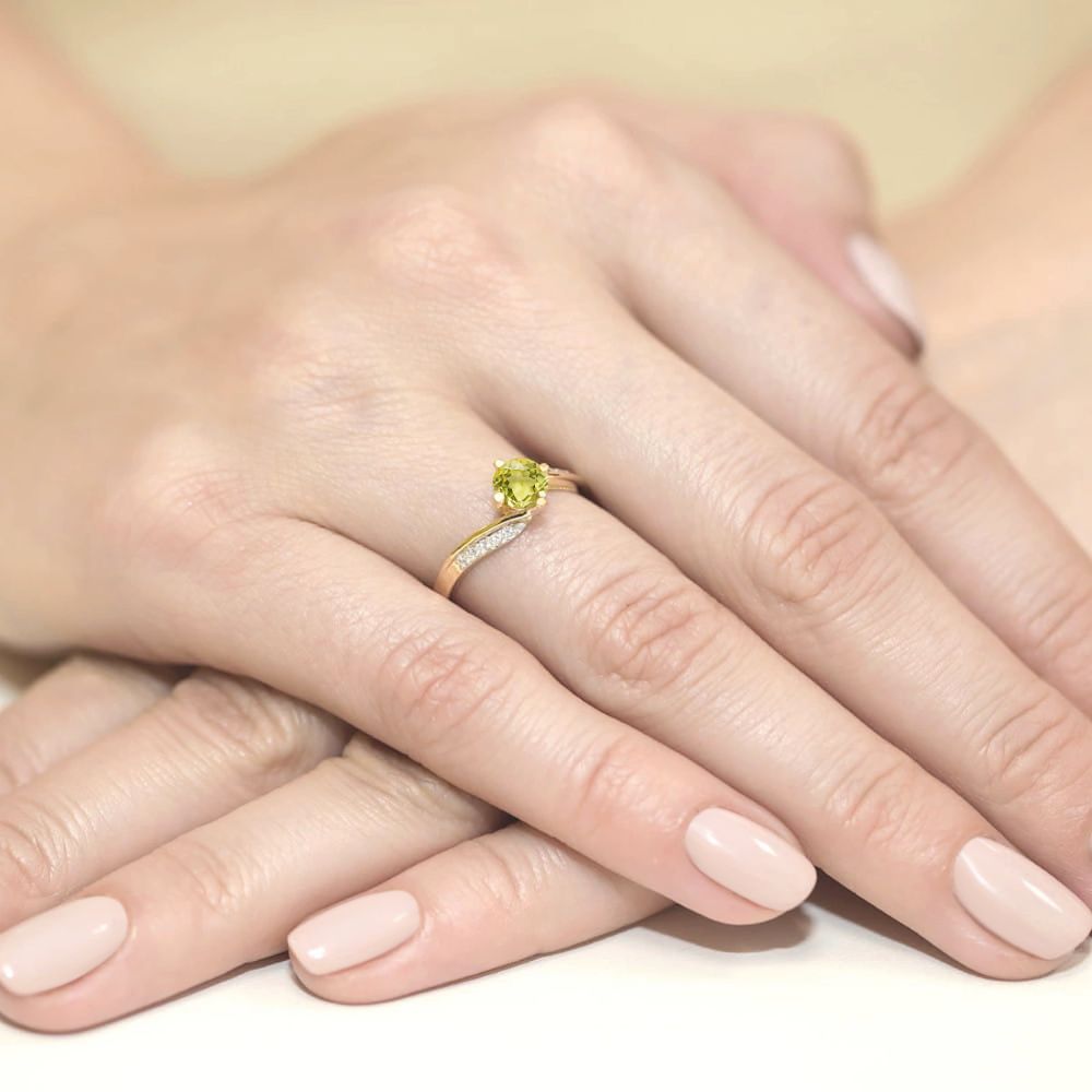Pierścionek z oliwinem 0,60 ct i brylantami, żółte złoto 585, zdjęcie na dłoni