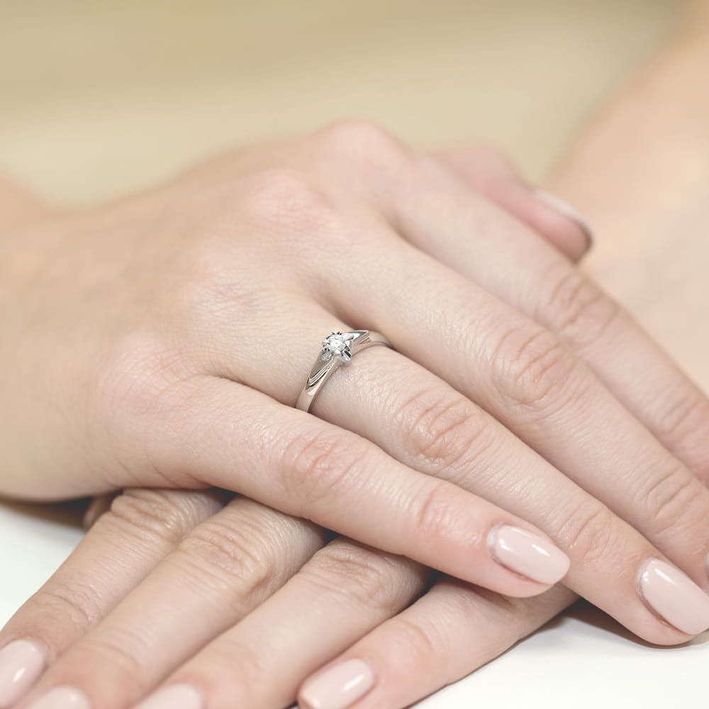 Pierścionek zaręczynowy z brylantem 0,10 ct, białe złoto 585, zdjęcie na dłoni