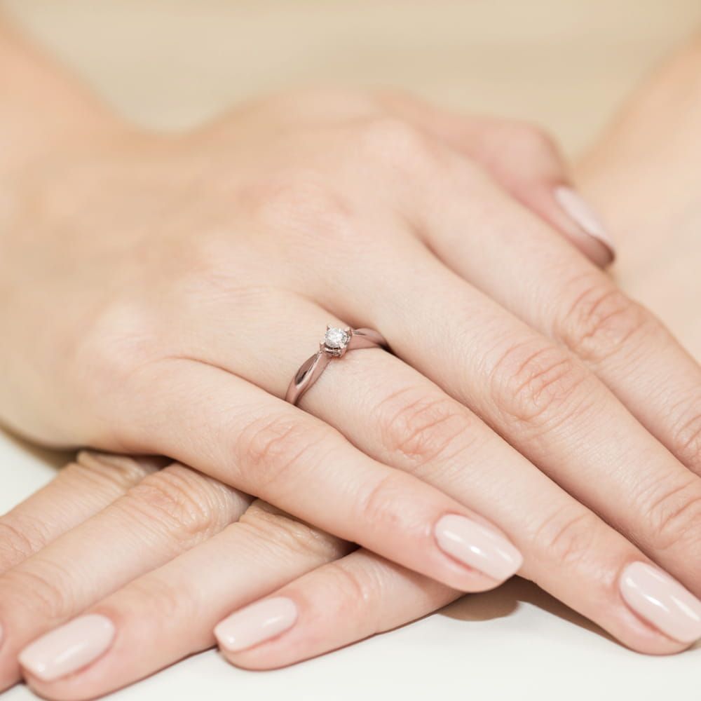 Pierścionek zaręczynowy z brylantem 0,12 ct, różowe złoto 585, zdjęcie na dłoni