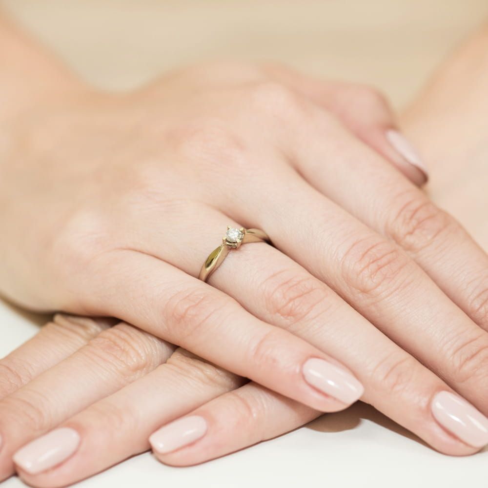 Pierścionek zaręczynowy z brylantem 0,12 ct, żółte złoto 585, zdjęcie na dłoni