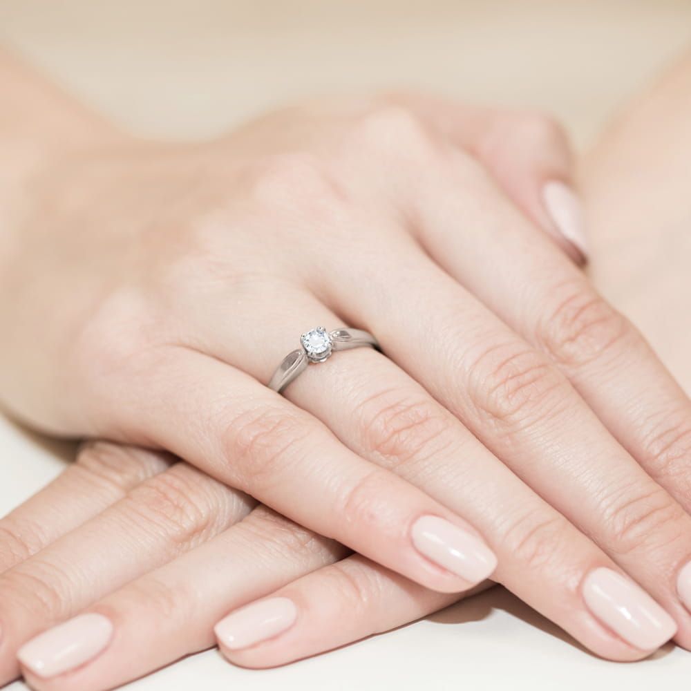 Pierścionek zaręczynowy z brylantem 0,24 ct, białe złoto 585, zdjęcie na dłoni