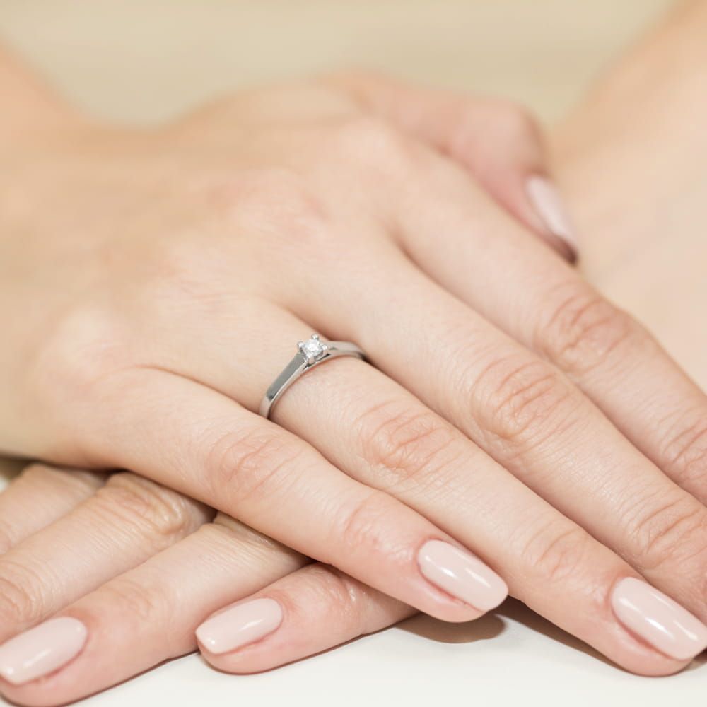 Pierścionek zaręczynowy z brylantem 0,12 ct, białe złoto 585, zdjęcie na dłoni