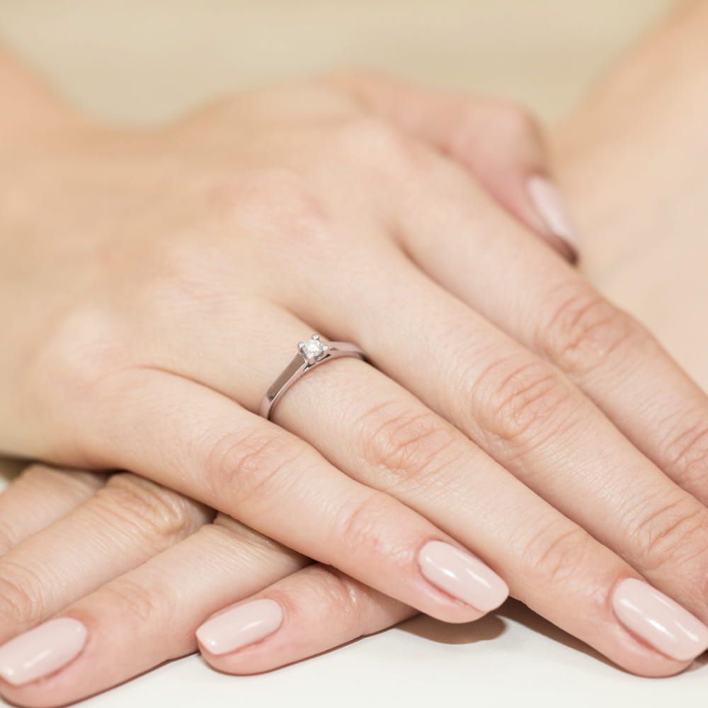 Pierścionek zaręczynowy z brylantem 0,12 ct, różowe złoto 585, zdjęcie na dłoni