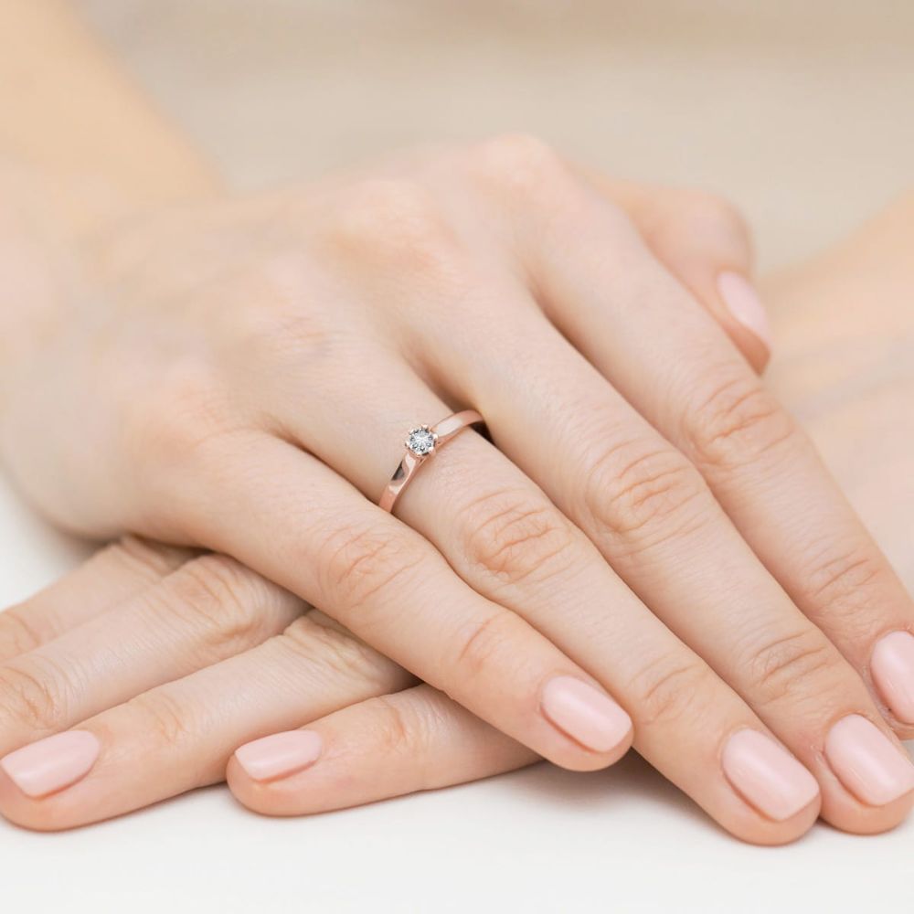 Pierścionek zaręczynowy z brylantem 0,12 ct, różowe złoto 585, zdjęcie na dłoni