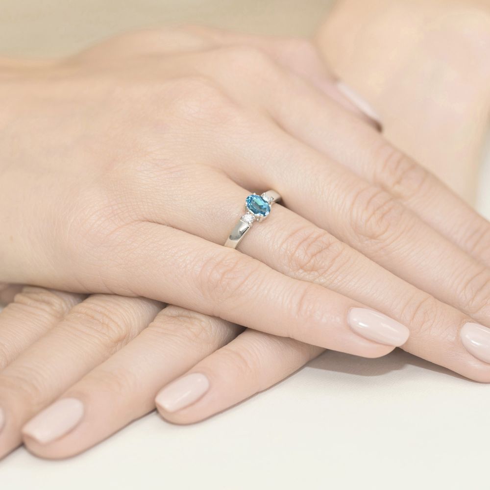Pierścionek z topazem Swiss Blue 0,50 ct i brylantami, białe złoto 585, zdjęcie na dłoni
