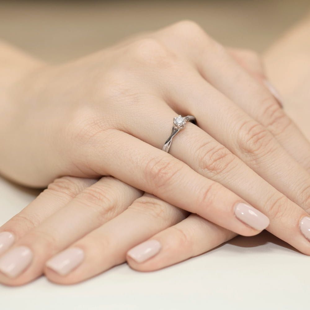 Pierścionek zaręczynowy z brylantem 0,23 ct, białe złoto 585, zdjęcie na dłoni
