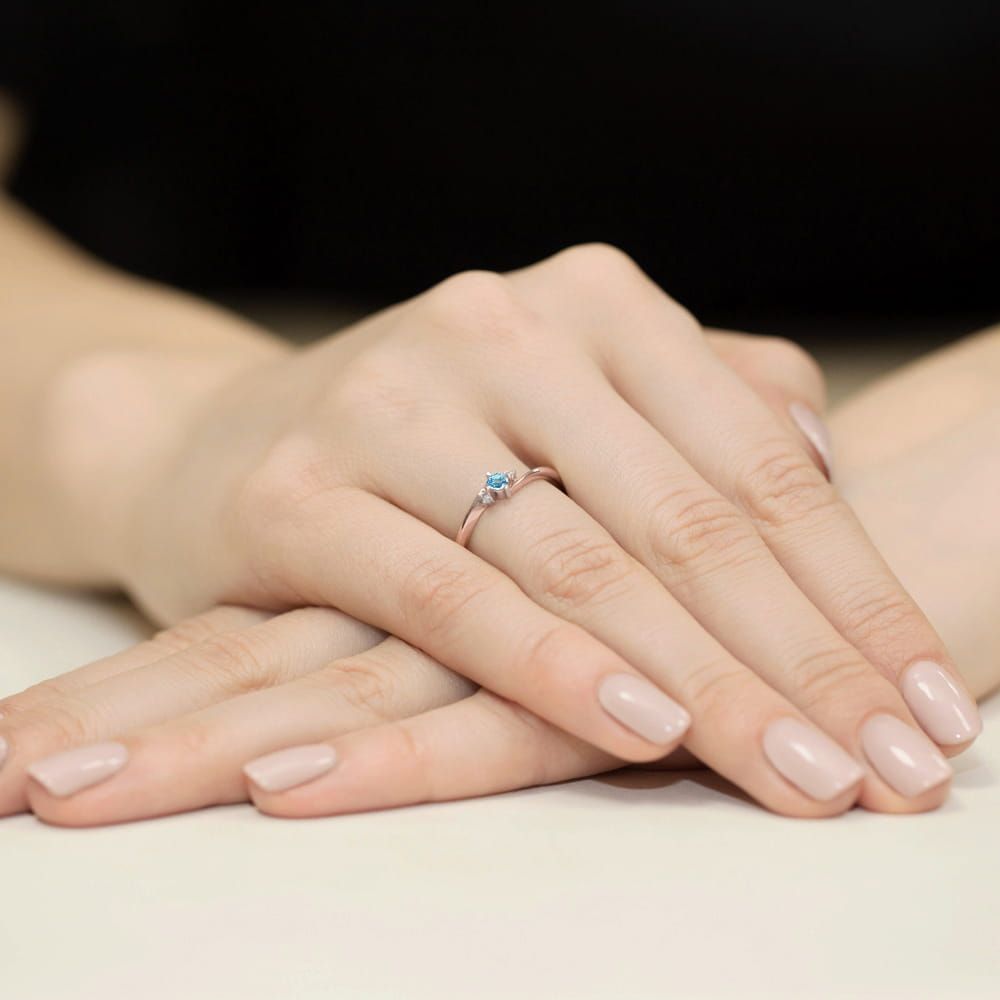 Pierścionek z topazem Swiss Blue 0,15 ct i brylantami, różowe złoto 585, zdjęcie na dłoni