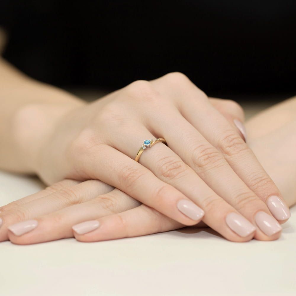 Pierścionek z topazem Swiss Blue 0,15 ct i brylantami, żółte złoto 585, zdjęcie na dłoni