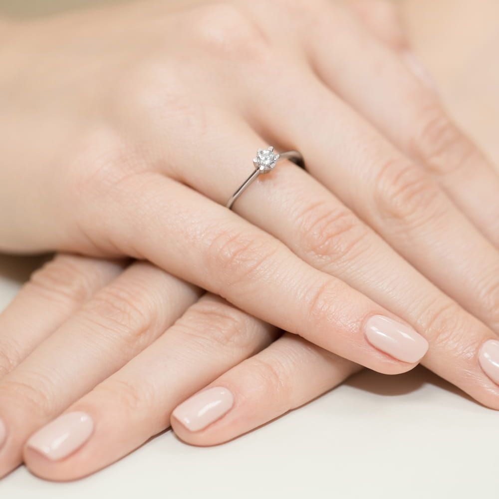 Pierścionek zaręczynowy z brylantem 0,23 ct, białe złoto 585, zdjęcie na dłoni
