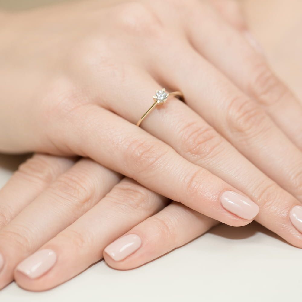 Pierścionek zaręczynowy z brylantem 0,23 ct, żółte złoto 585, zdjęcie na dłoni