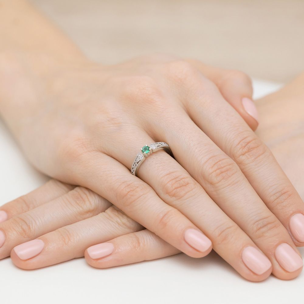 Pierścionek ze szmaragdem 0,15 ct i brylantami, białe złoto 585, zdjęcie na dłoni