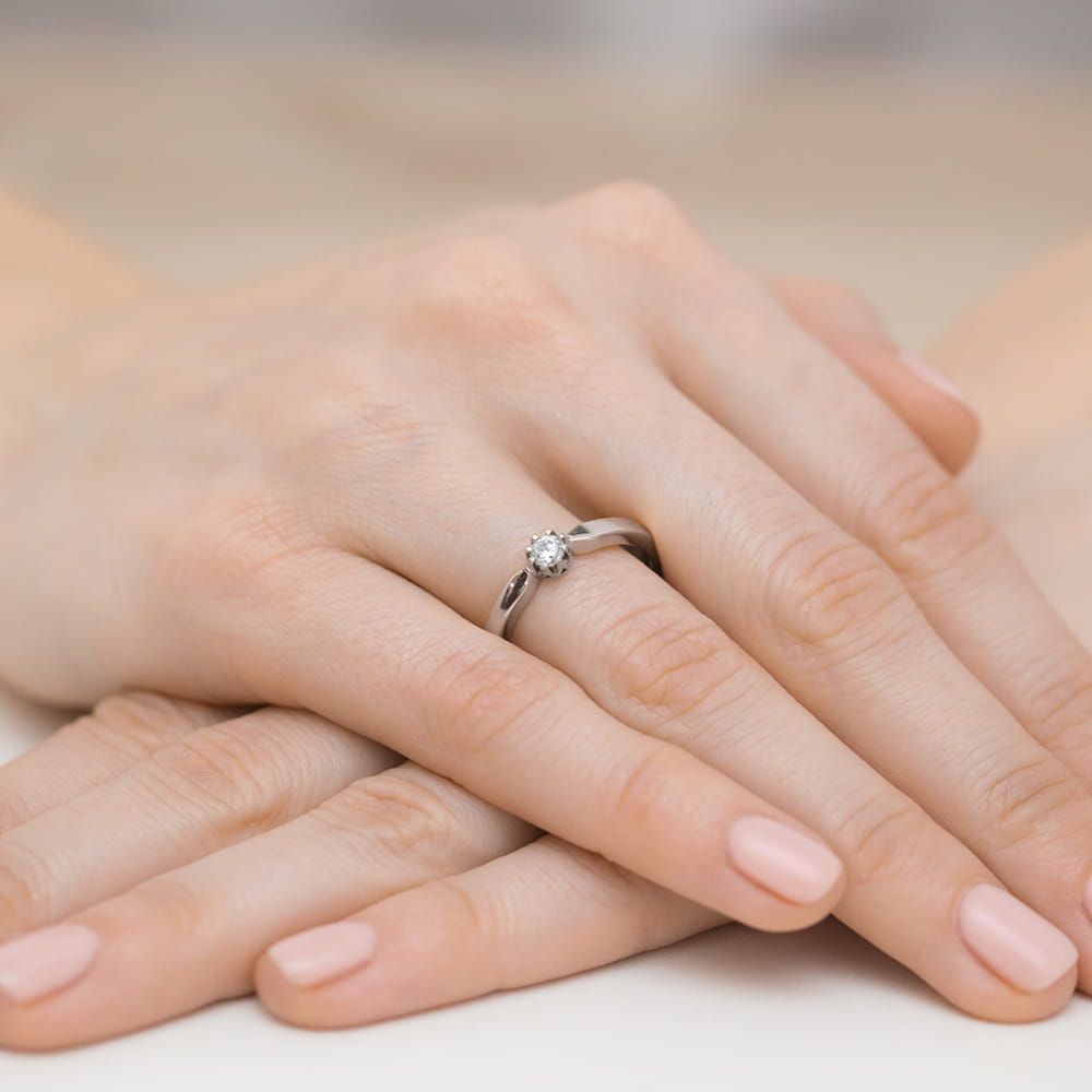 Pierścionek zaręczynowy z brylantem 0,15 ct, białe złoto 585, zdjęcie na dłoni