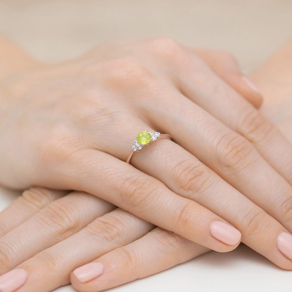 Pierścionek z oliwinem 0,60 ct i brylantami, różowe złoto 585, zdjęcie na dłoni