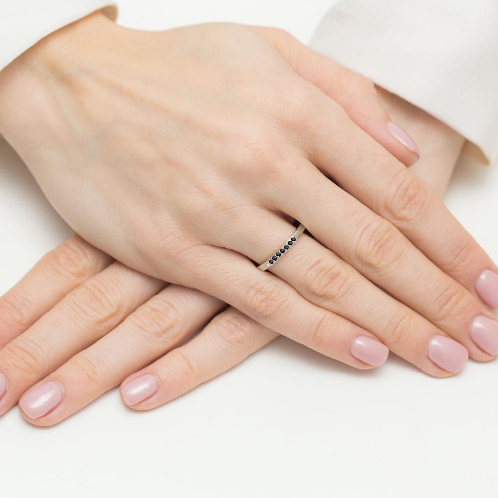 Pierścionek z czarnym diamentem 0,12 ct i czarnymi brylantami, białe złoto 585, zdjęcie na dłoni